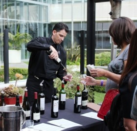 A host pours a taste of one of Fleming's new wines available by the glass.