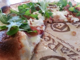 Fennel sausge pizza, topped with arugula.